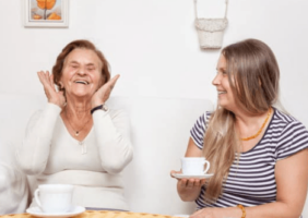 Mother and daughter laughing over tea