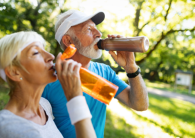 elderly couple drinking water in the park