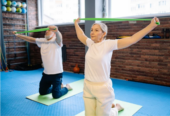 Elderly couple doing exercise with yoga mats and resistance bands