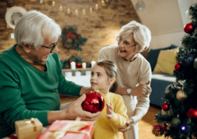 Grandparents decorating the Christmas tree with Grandchild