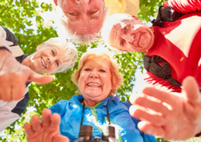 Elderly people huddles around a camera on a sunny day