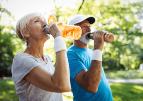 Elderly couple drinking water in the summer sun