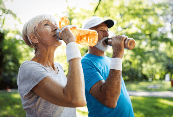 Elderly couple drinking water in the summer sun