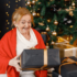 Elderly Woman Opening Chrismtas Presents Beside the Christmas Tree