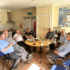 7 Elderly Men sit around a table to enjoy tea and scones